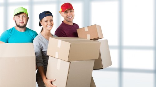Movers handling desks and IT items during an office relocation