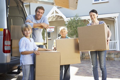 Mover wearing PPE handling boxes carefully inside a property