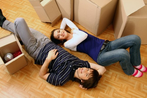 Movers carrying household items through a central London property